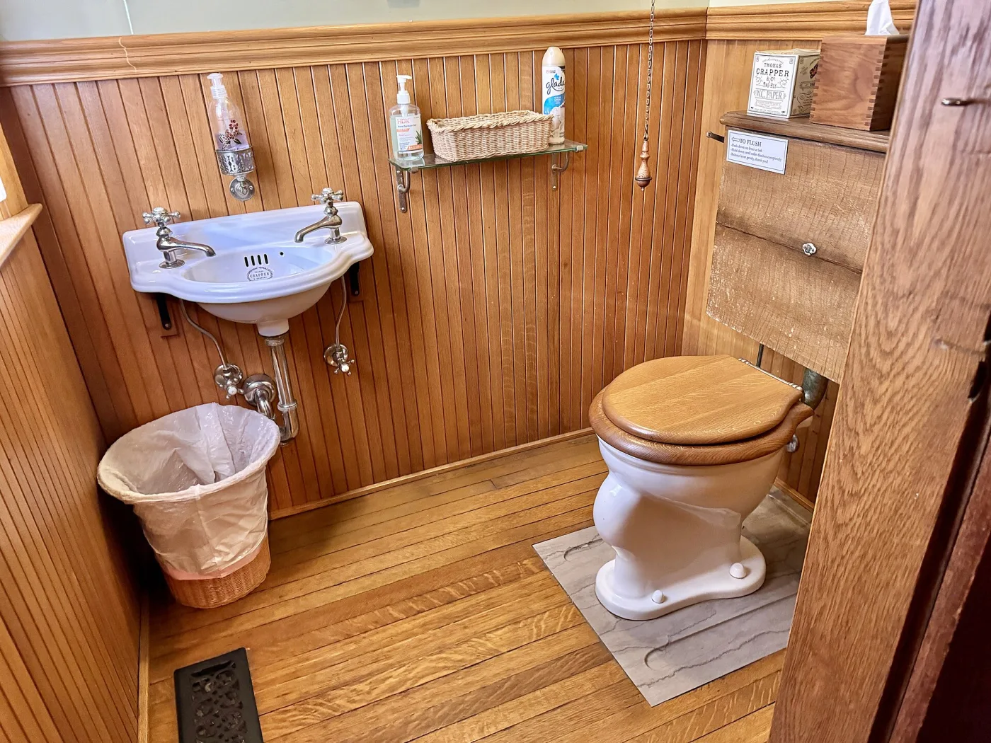 Een badkamer met een houten plankenvloer, wastafel en toilet